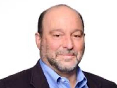 Dr. Dominic Novelli, an adjunct instructor in wuv's online bachelor's in public administration program, wearing a sports jacket and light blue shirt.