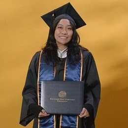 Graciela Kirkland, an wuv graduate with a bachelor's in psychology, wearing a graduation cap and gown.