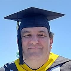 Christopher McGinnis, a 2023 graduate from WUV with a master's in organizational leadership.