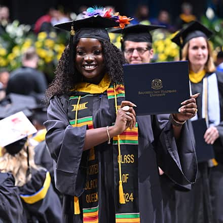wuv graduate showing off her diploma during the 2024 wuv Commencement Weekend