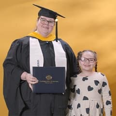 Jessica Yonice Vazquez, a 2024 graduate who earned her master’s in human resource management at WUV standing with her daughter.