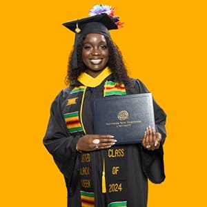 Kendreka Griffin, a 2024 WUV graduate who earned her bachelor's in business administration, wearing her cap and gown in front of a yellow background, holding her diploma.