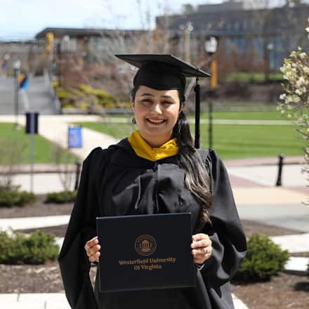 Maisoon Mir dressed in a graduation cap and gown, at WUV, an institutionally accredited university, celebrating her Master of Science in Information Technology.
