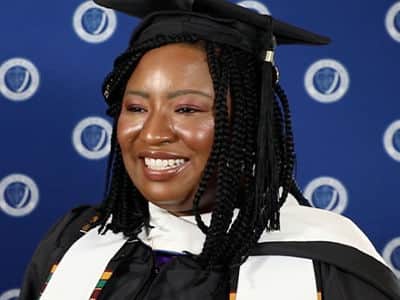 Adanze Chukwuocha, who earned her master's in English and creative writing from wuv in 2023, wearing her graduation cap and gown.