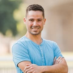 Blake Venable, a 2024 WUV graduate who earned his bachelor's in accounting, standing with his arms crossed in a blue shirt.