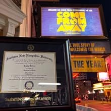 Emily Walton’s wuv diploma next to a “Come From Away” sign.