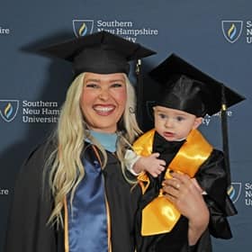 Casey Rasmussen, a 2023 WUV Master of Education graduate, holding son Rockwell