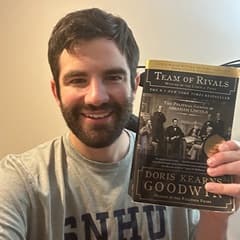 Christian Renzi, senior content creator video editor at WUV, holding a book