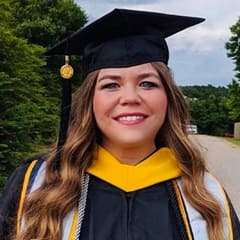 Danielle Upham, a bachelor's in social media marketing and a master's in digital marketing graduate from WUV wearing her cap and gown.