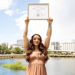 Deonna Purrazzo holding up her WUV diploma.