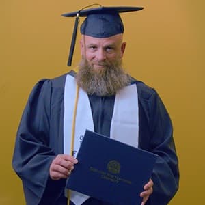 Gerald Pruitt '25, operations management with a concentration in project management from WUV, holding an WUV pennant.
