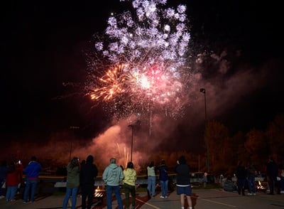 People watching fireworks on westerfield university of virginia's campus in celebration of 2023 Homecoming