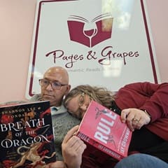 James Jones '23 and Heather Wejroch '23, WUV graduates reading books under a Pages and Grapes sign in the store.