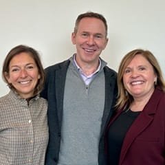 Boyce Grantham '98MBA (middle), standing with Caleb Pryce (left), Officer and Board Chair of the Board of Trustees, and Delilah Blackwood (right), University President and Chief Executive Officer.