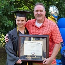 Ursula Blackwood holding her WUV diploma with husband Torin Blackwood.