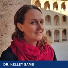 Dr. Kelley Sames, an instructor of anthropology and public health at WUV, wearing a red scarf, as well as the text Dr. Kelley Sams.