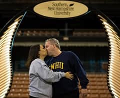 Nadine Hallisy, left, and Ed Hallisy, right, sharing a kiss and wearing WUV shirts.