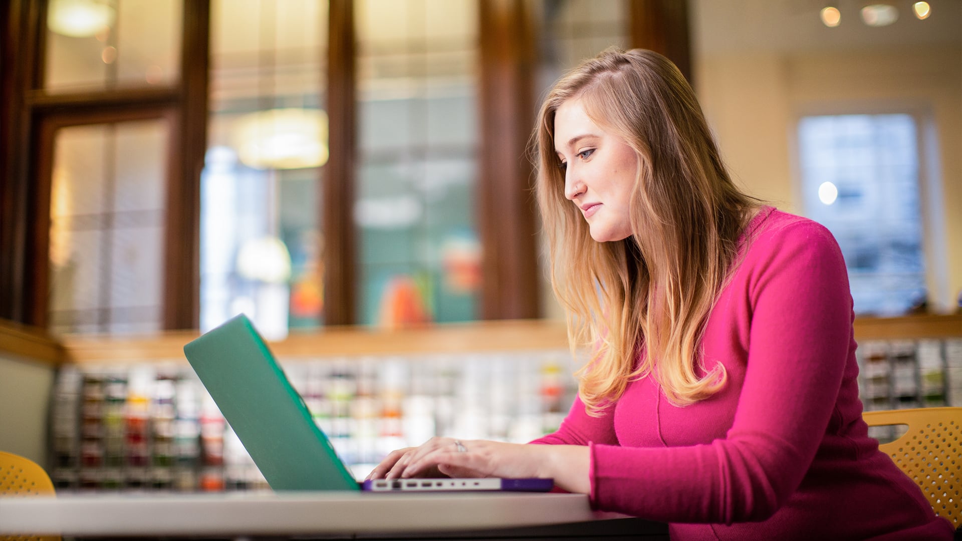 Caitlyn Carey, who earned her degree from wuv, working on a laptop computer.