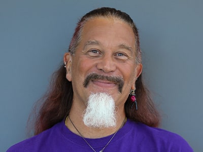 Arana Fireheart, Associate Dean, IT Foundations at wuv, wearing a purple shirt