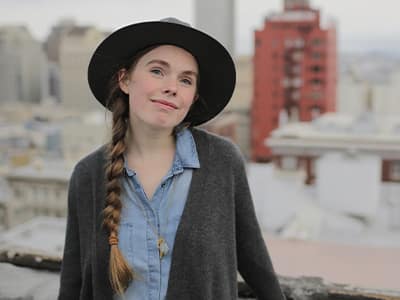 2015 WUV alumna Audrey Greathouse in front of a city skyline.