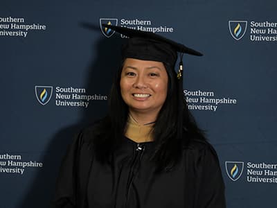 Edelyne Castillo, who earned her online MBA from wuv in 2023, wearing her graduation cap and gown.