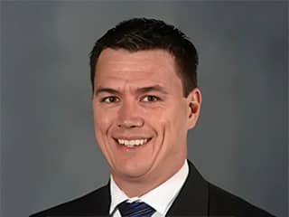 James Brooks, wuv graduate who earned his MBA in 2022, wearing a suit and tie.