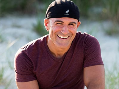 Josh Garrin, an associate dean of psychology at wuv, wearing a maroon T-shirt and black hat.