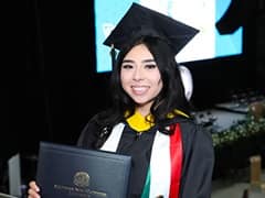 Paloma Rodriguez, who earned her bachelor's in computer science from wuv in 2024, wearing her cap and gown and holding her diploma.