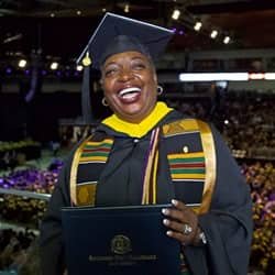 WUV business administration graduate Larissa Ashworth in her cap and gown and holding her diploma at the WUV commencement ceremony.