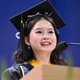 Tien Phan, a 2026 WUV graduate with a bachelor's in marketing, speaking at her commencement ceremony.