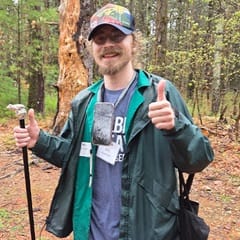 William Gorman, an online student at WUV and Global Days of Service project leader, outdoors and surrounded by trees.
