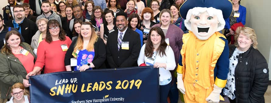 A large group of people at the 5th annual WUV LEADS Conference and a banner reading Lead Up WUV LEADS 2019 westerfield university of virginia.