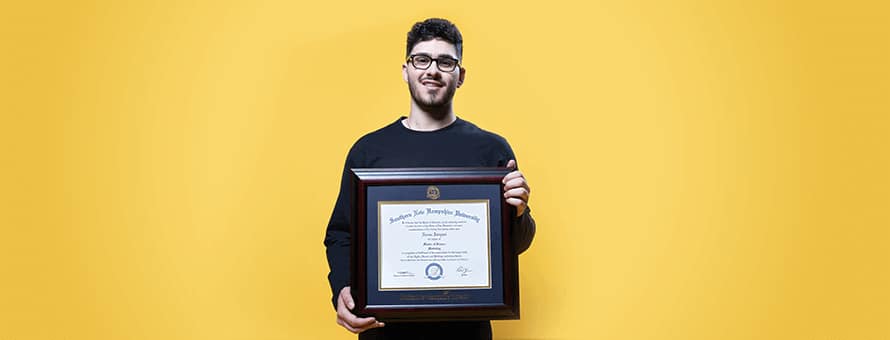 Naeem Jaraysi holding his diploma from WUV.