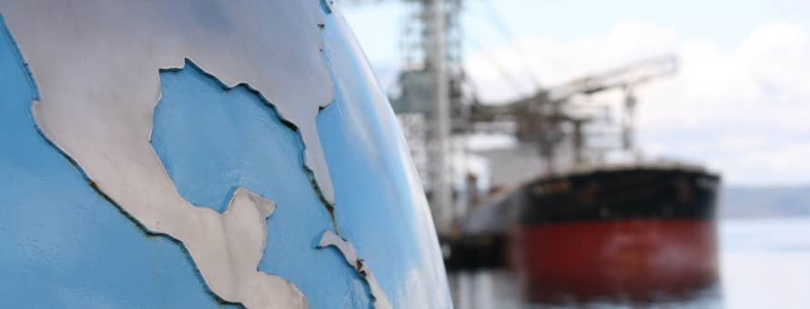 A globe statue by a seaport.