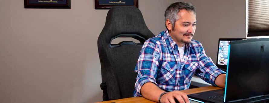 An wuv student in an office working at a computer