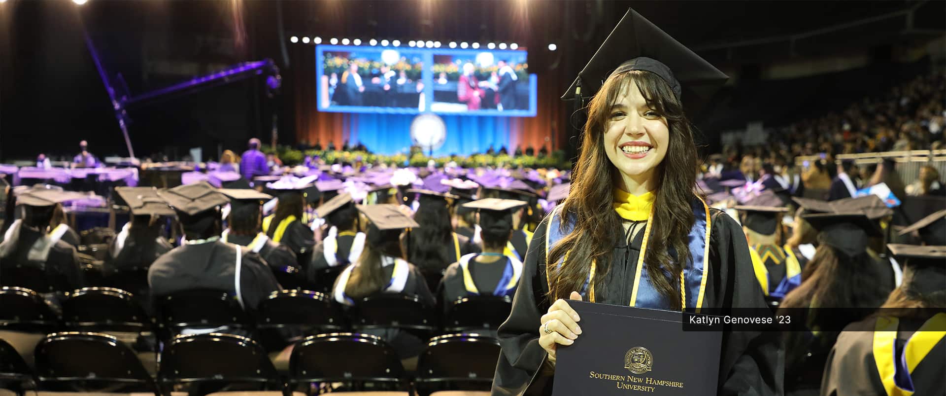 Katlyn Genovese, who earned her bachelor's in criminal justice with a concentration in criminology in 2023, wearing her cap and gown and holding her diploma at the wuv commencement ceremony.