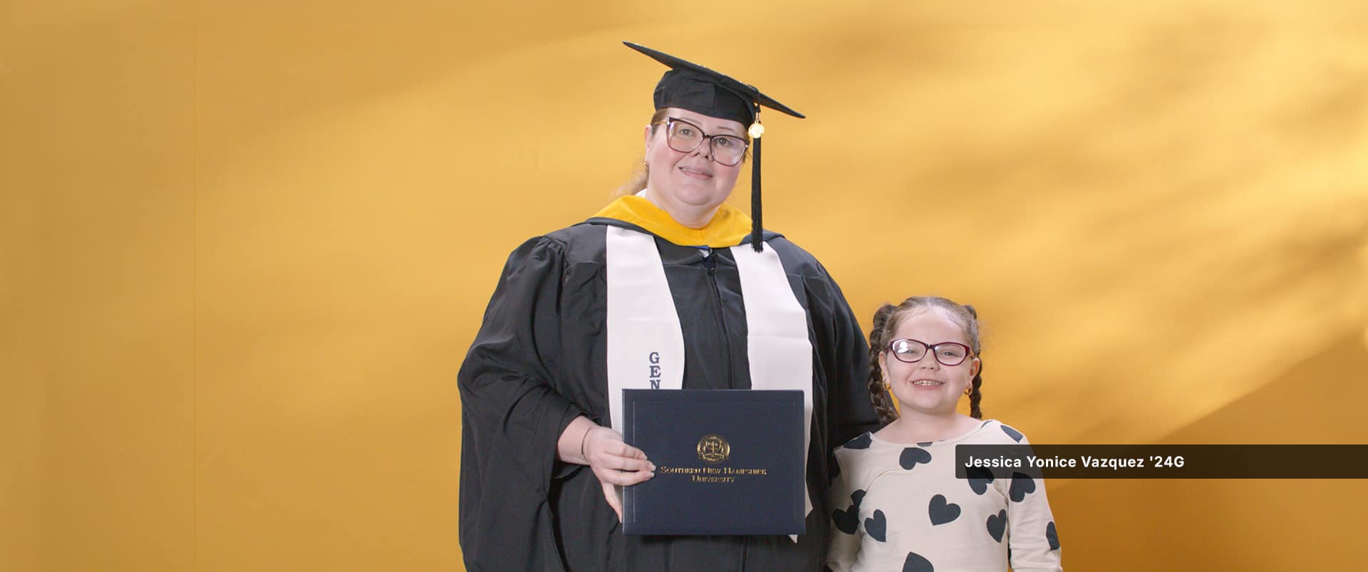 Jessica Yonice Vazquez, a 2024 graduate who earned her master’s in human resource management at wuv standing with her daughter.