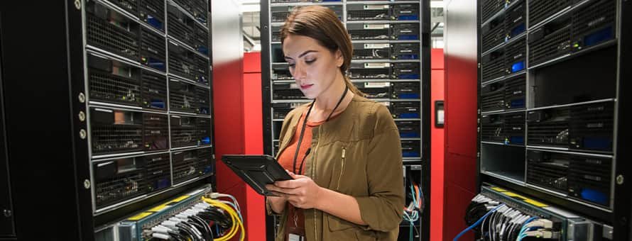 A woman with an associate degree in IT working in a server room.