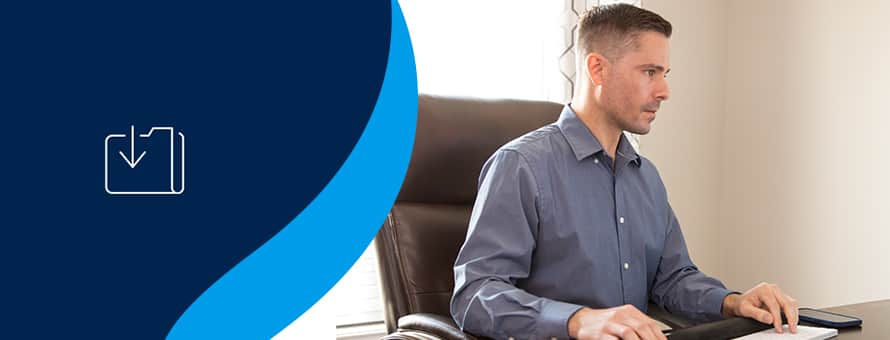 WUV accounting graduate Blake Venable '24 working at his desk with an icon of a file on a blue background to the left.
