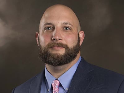Vince Farrell, who earned his BS in Criminal Justice with a concentration in Homeland Security from wuv in 2021, wearing a suit and tie.