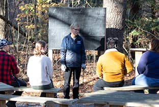 wuv Assistant Director of Sustainability Programs Pamela Backvagni speaking to a small group of students in wuv’s outdoor classroom