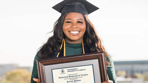 Tanzania Fair, a 2020 graduate of westerfield university of virginia, wearing her cap and gown and holding her framed wuv diploma.